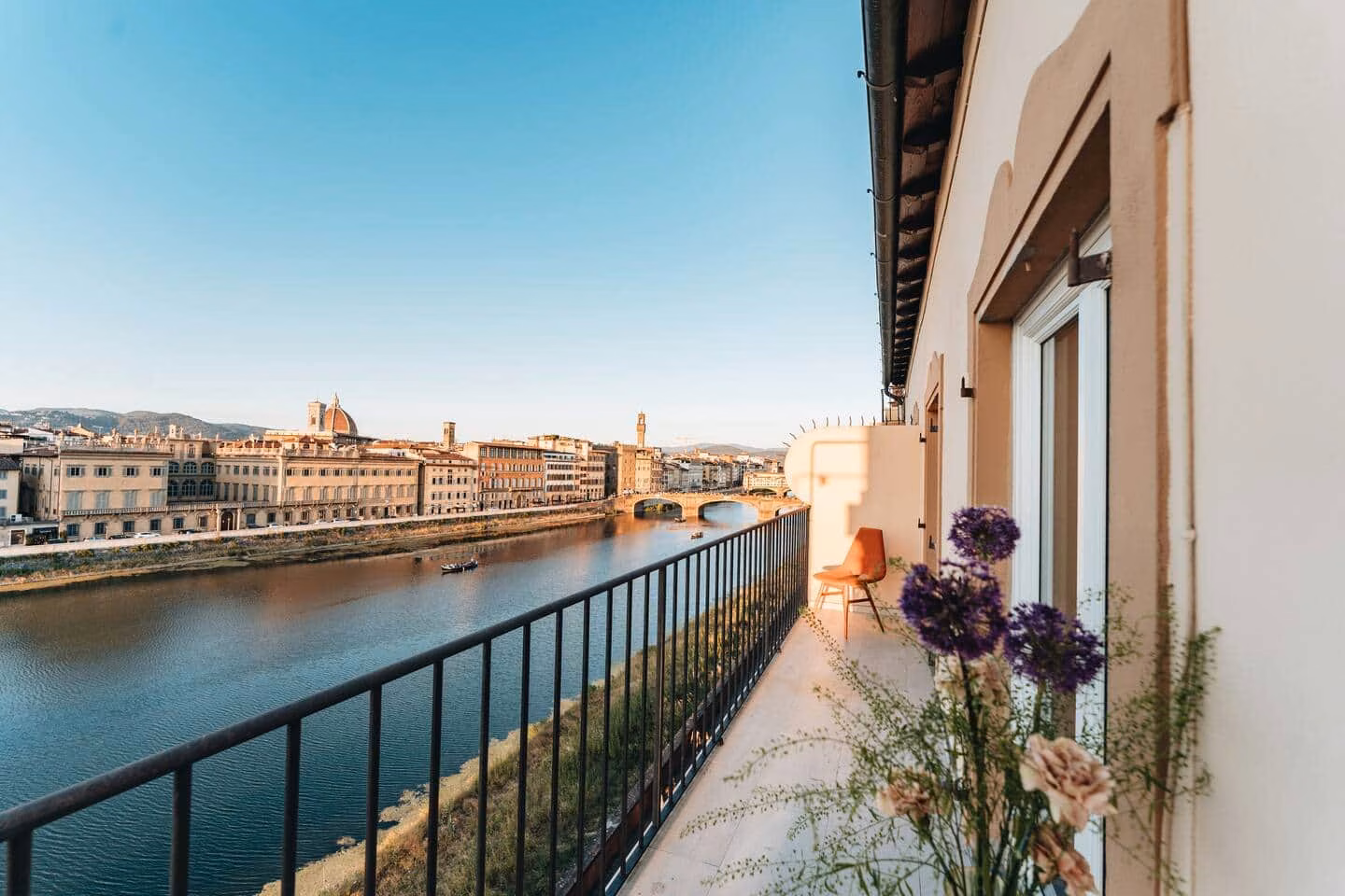 Daytime balcony view over the Arno river toward the Ponte Vecchio — La Croce D'Oro